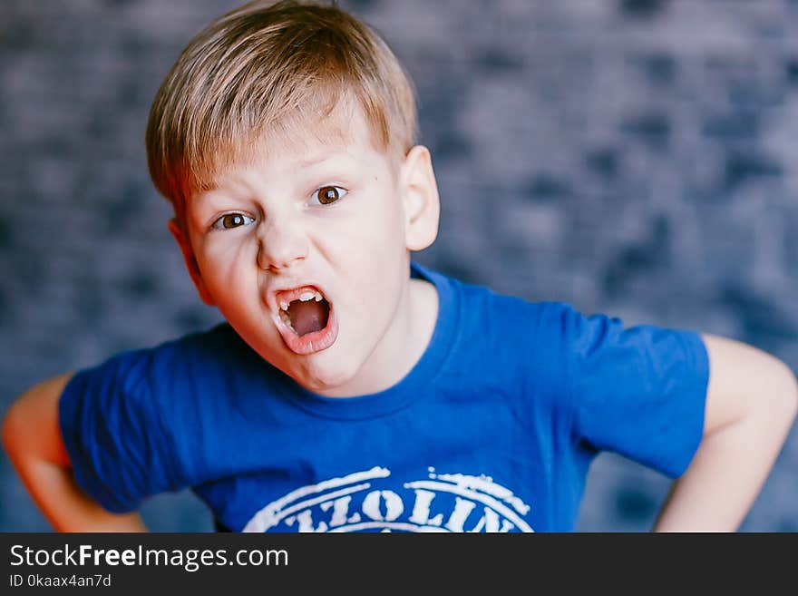 Five year old boy grimaces and open his mouth in front of the camera. Five year old boy grimaces and open his mouth in front of the camera