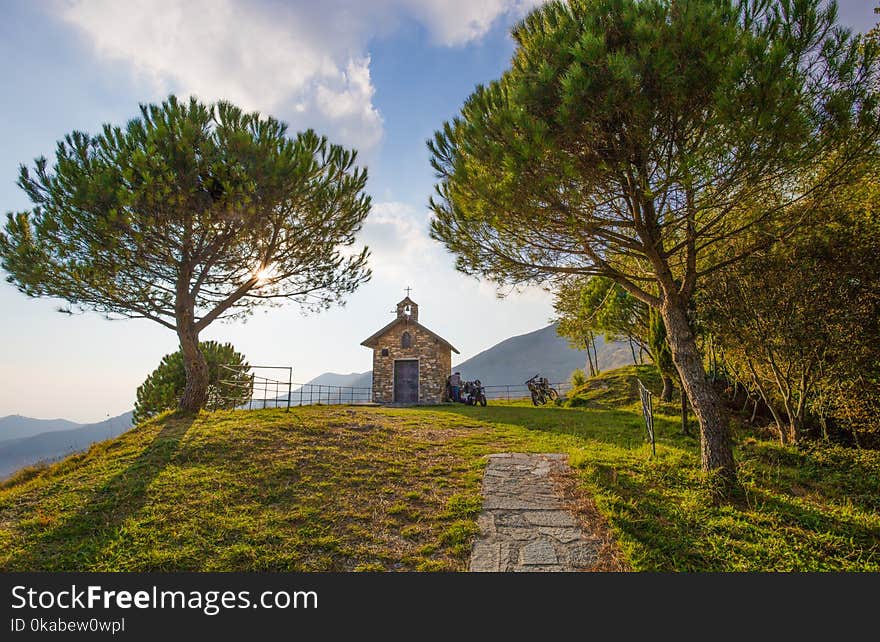 Country road uphill through the trees and a small church/mountain/autumn/colors/trees