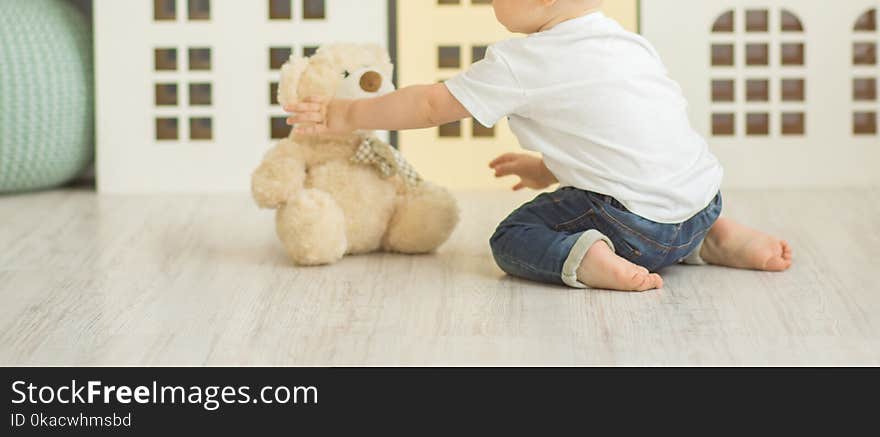 Litle boy sits on the floor at bedroom