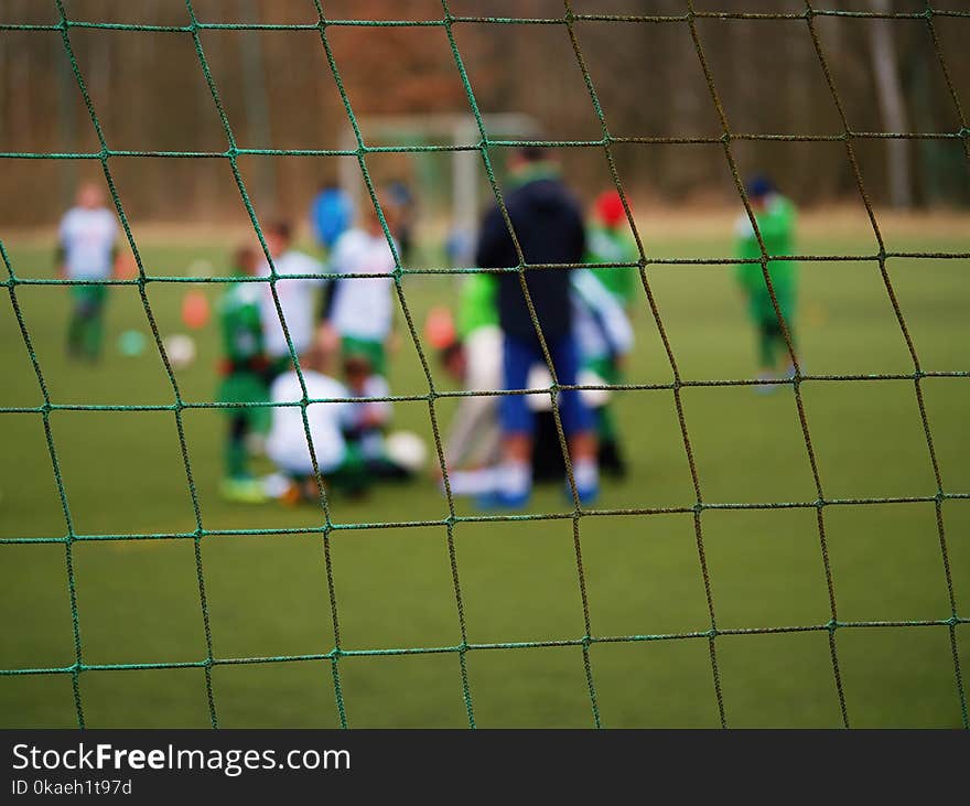 Football gate net. Soccer gate net. In blurry background stand players. Training of junior team.