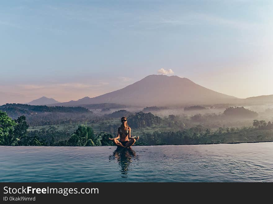 Series traveling girl in Asia. beautiful girl with long dark hair in swimming suit in beautiful nature place in Bali, posing near swimming pool with volcano Agung view. Series traveling girl in Asia. beautiful girl with long dark hair in swimming suit in beautiful nature place in Bali, posing near swimming pool with volcano Agung view