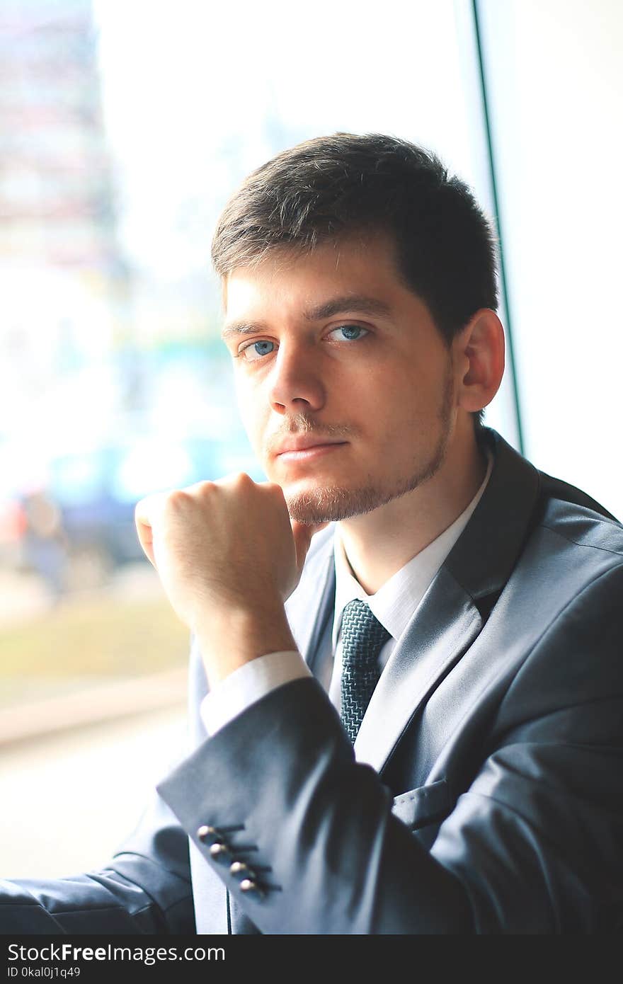 Confident young businessman on background of office