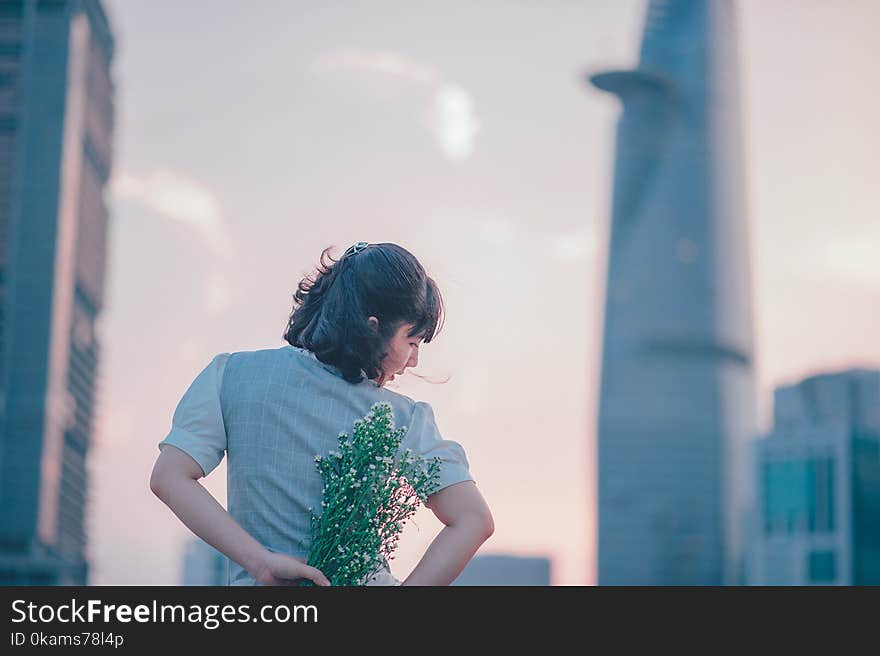 Selective Focus Photo of Woman Holding White Flower