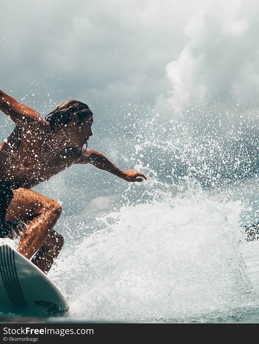 Man Riding White Surfboard