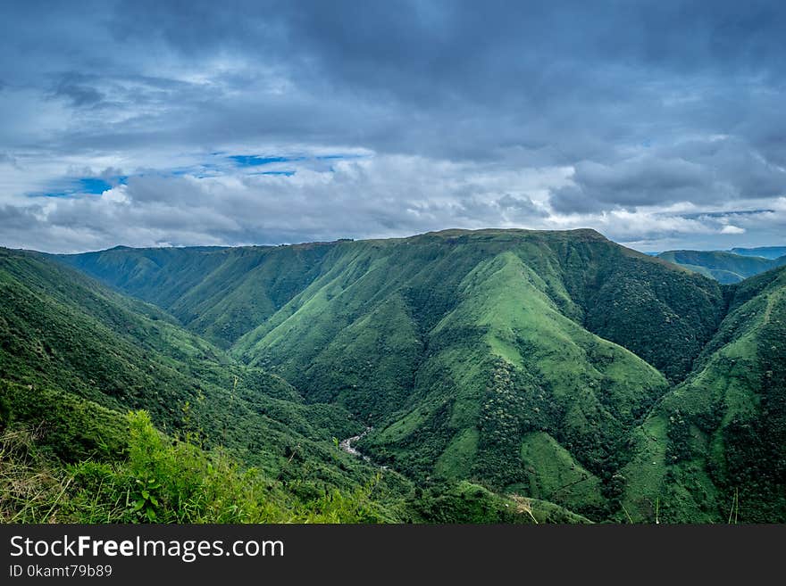 Landscape Photography of Green Mountains Under Cloudy Sky