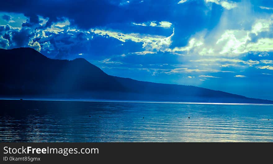 Silhouette of Mountain Near Water at Daytime