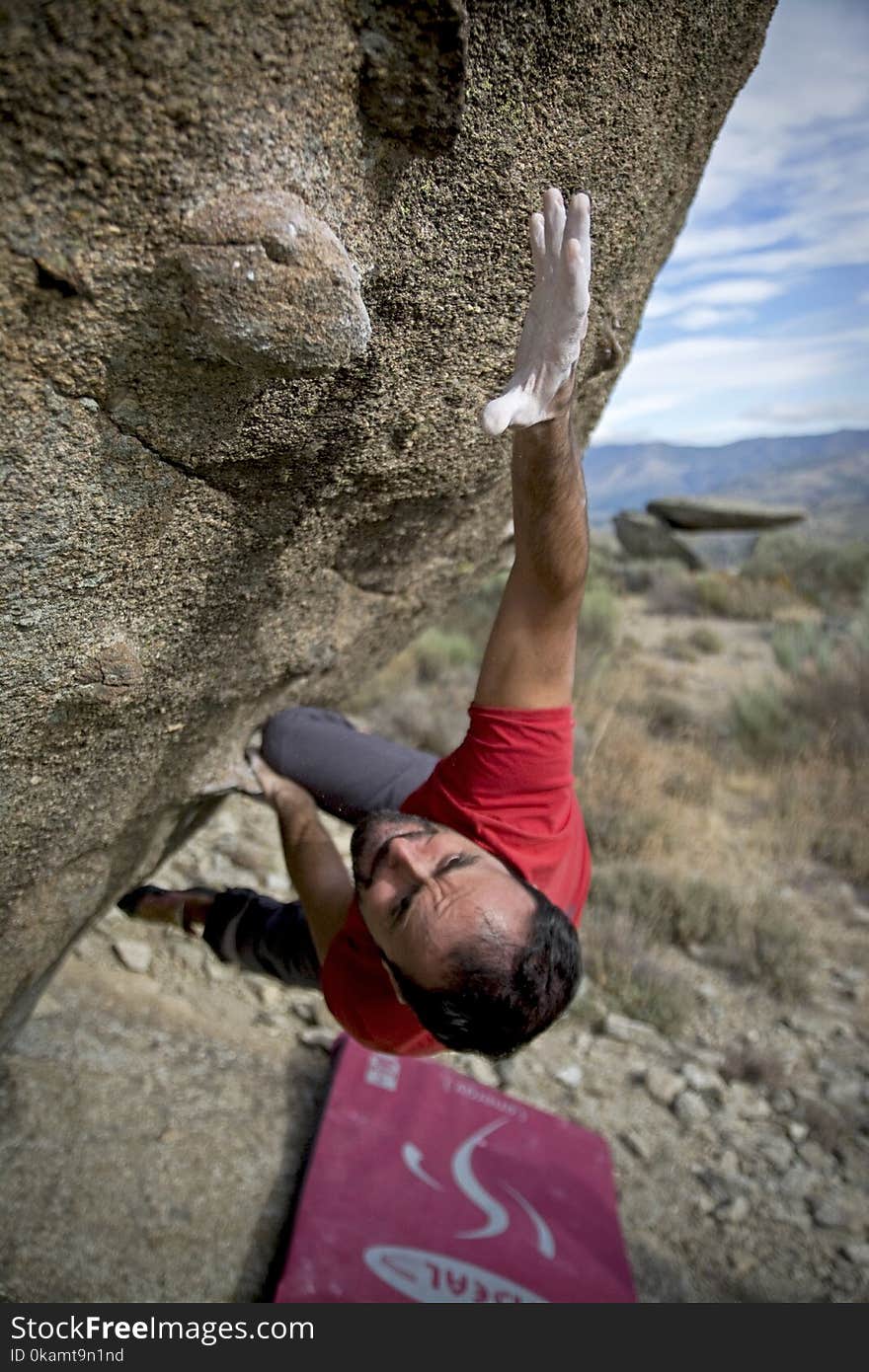 Man Climbing on Gray Concrete Peak at Daytime