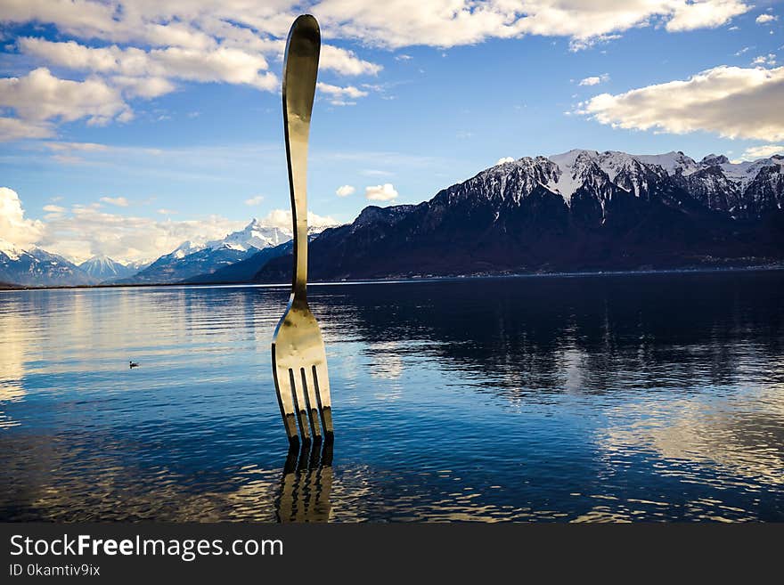 Gray Stainless Steel Fork on Water With Overlooking Mountain at Daytime