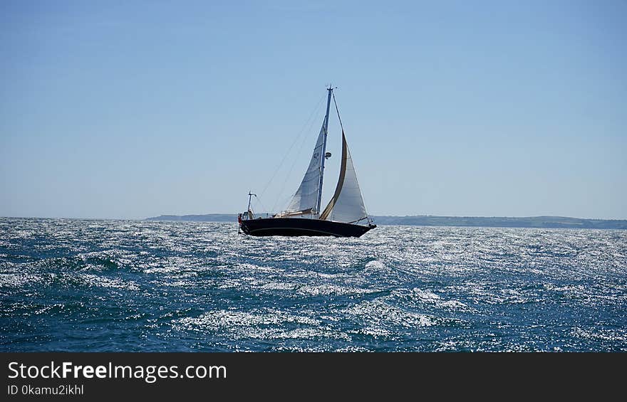 White and Black Sail Boat on Ocean