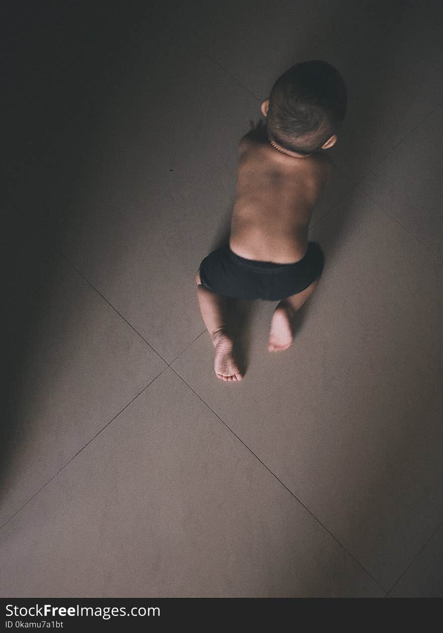 Toddler in Black Shorts Crawling on Grey Floor Tiles