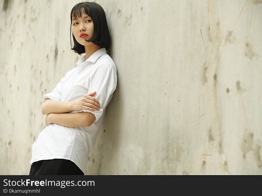 Woman Leaning on Concrete Wall