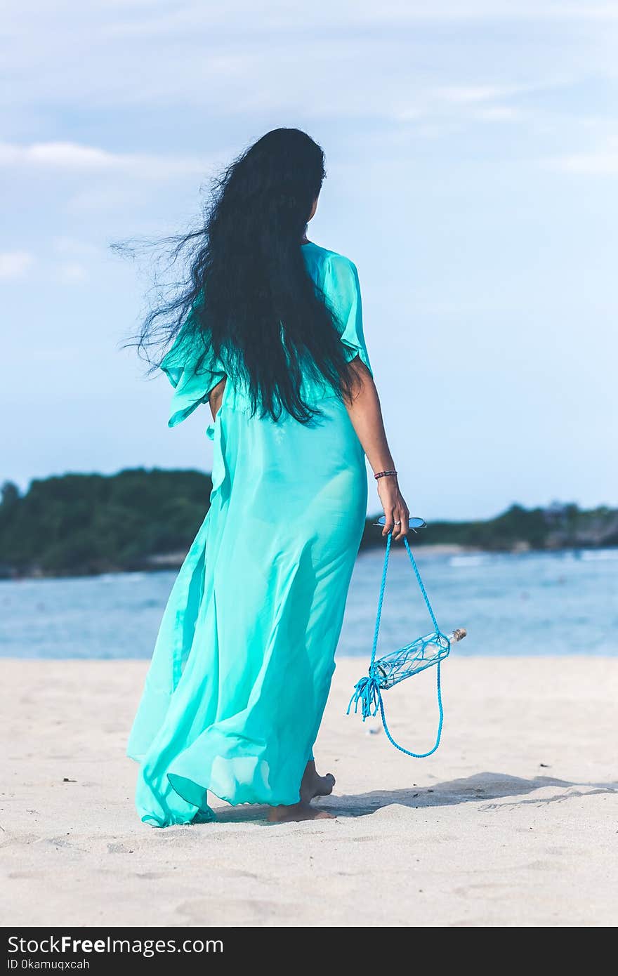 Woman in Teal Dress Standing on Beach