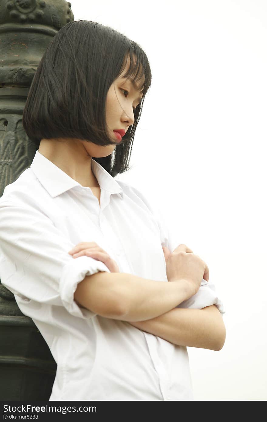 Woman Wearing White Dress Shirt Standing Near Concrete Statue