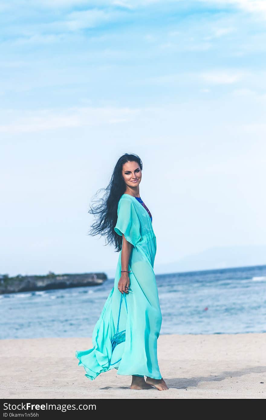 Woman in Teal Dress on Seashore