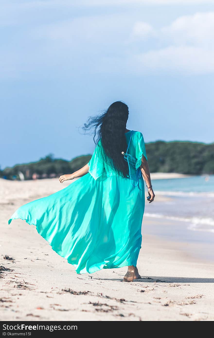 Woman Wearing Teal Dress While Walking Near Body of Water