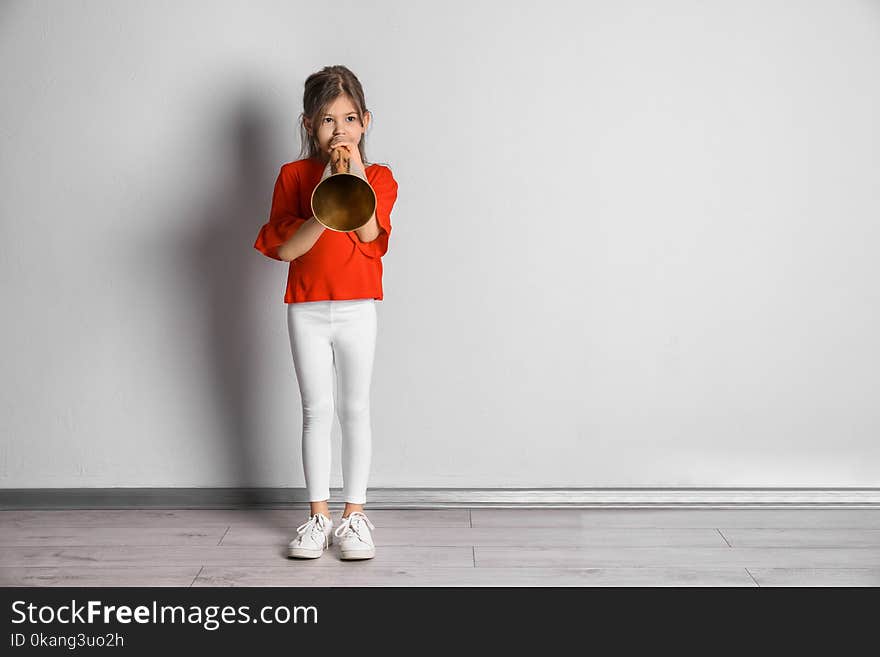 Adorable Little Girl With Vintage Megaphone Near Wall