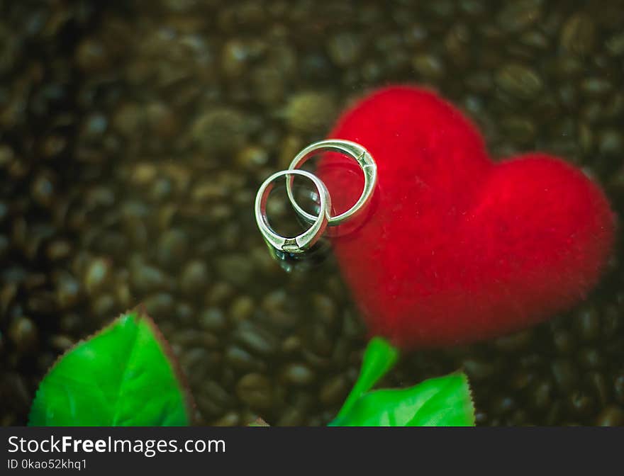 Background Silver ring couples are placed on red hearts and coffee.background noise and blurred. At shop.