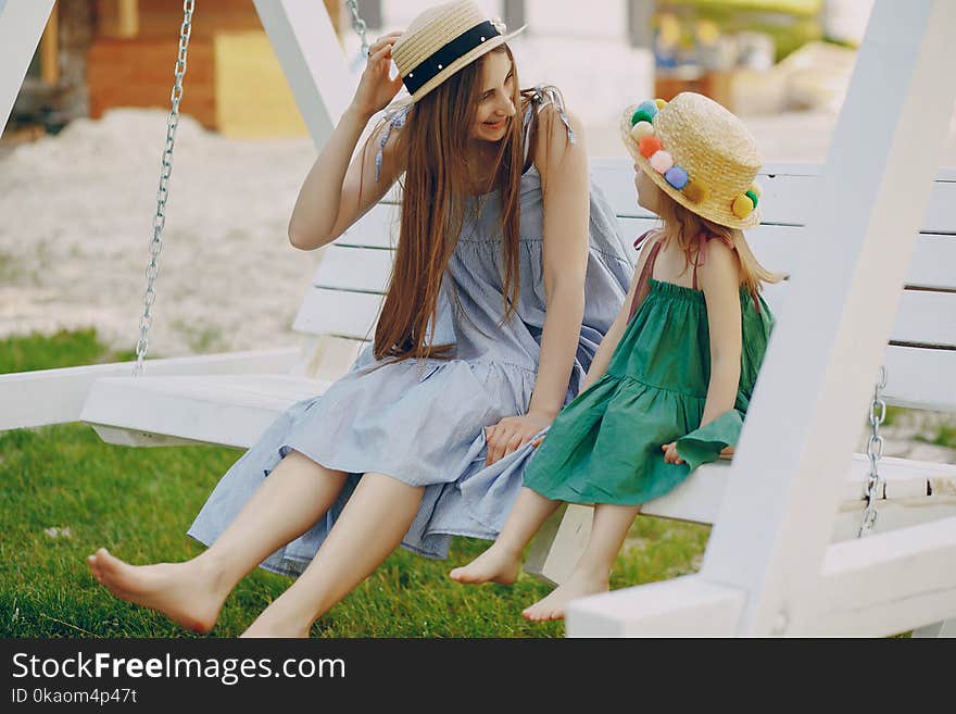 A beautiful young mother plays on the beach with her little daughter. A beautiful young mother plays on the beach with her little daughter