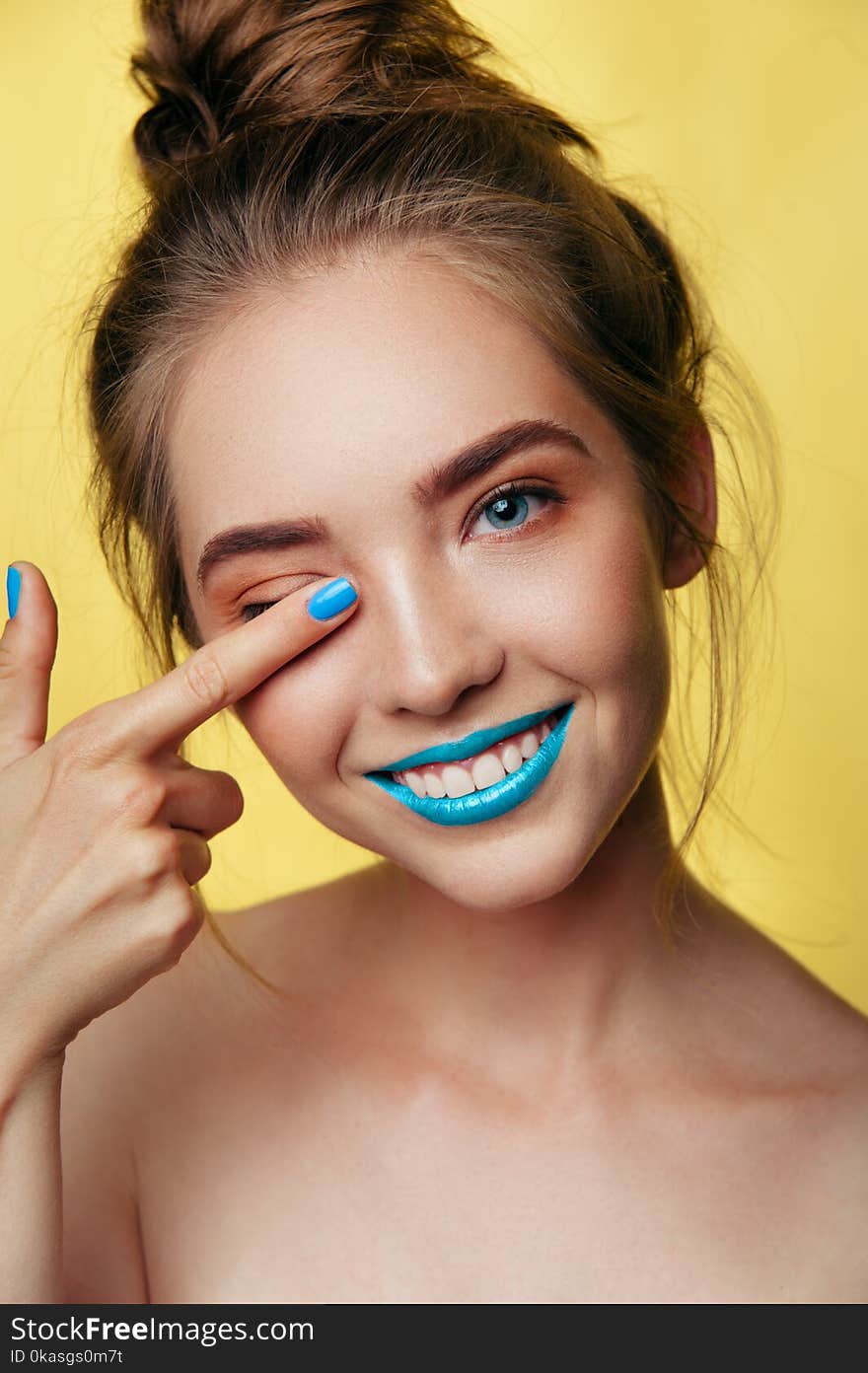 Beauty art portrait of white young smiling girl in pastel tones blue caramel makeup. Vertical photo