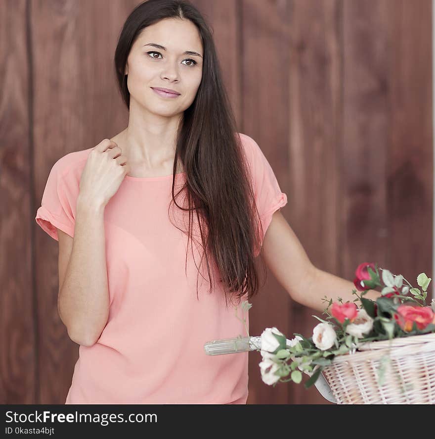 Portrait of a young woman with Bicycle and spring flowers in a basket.