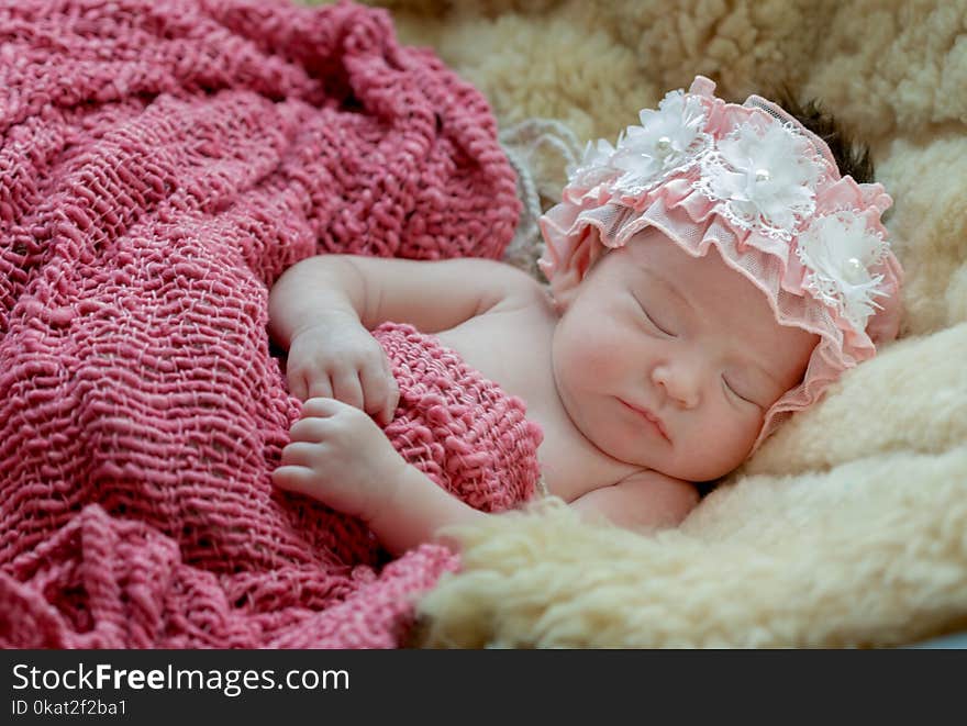 born baby girl is sleeping on fur blanket