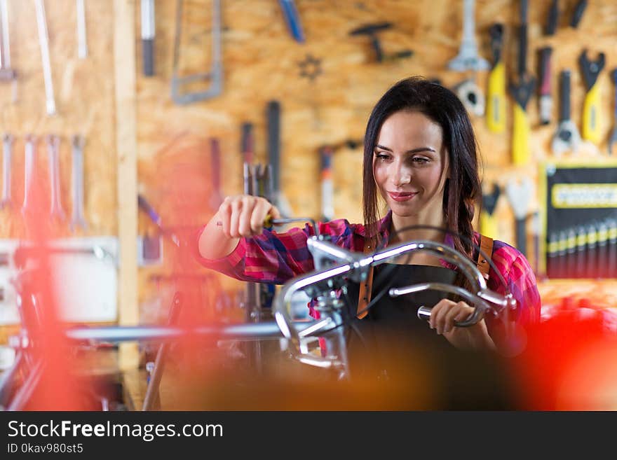 Young woman working in a bicycle repair shop