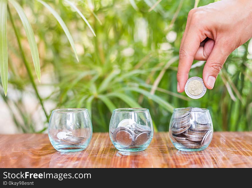 Hand of female putting coins in jar with money stack step growing growth saving money.Money Saving Ideas