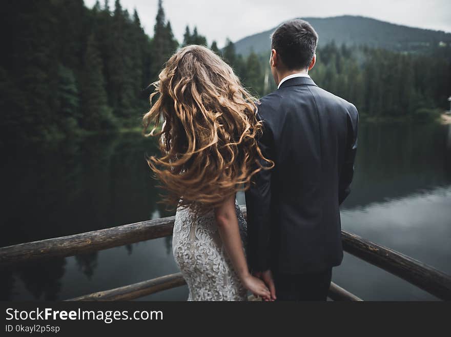 Beautiful wedding couple near lake with perfect view