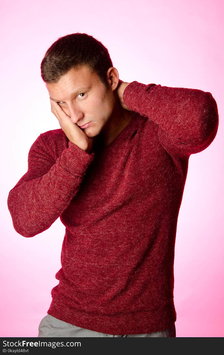 Handsome man in sweater. Pink background. Spring. and blossom