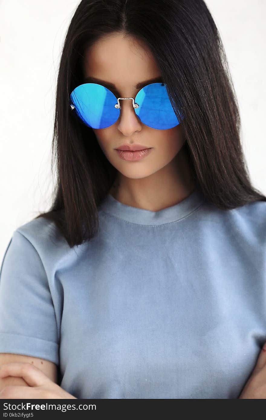 Fashion interior photo of beautiful young woman with long dark hair in elegant cozy clothes and sunglasses. Fashion interior photo of beautiful young woman with long dark hair in elegant cozy clothes and sunglasses