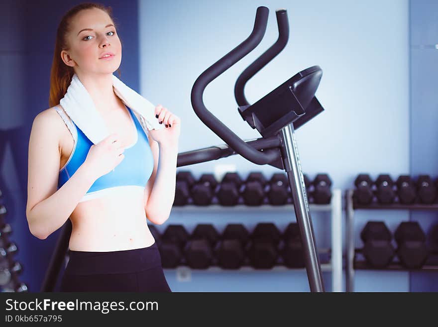 Beautiful girl at the gym exercising on trainers. Beautiful girl.