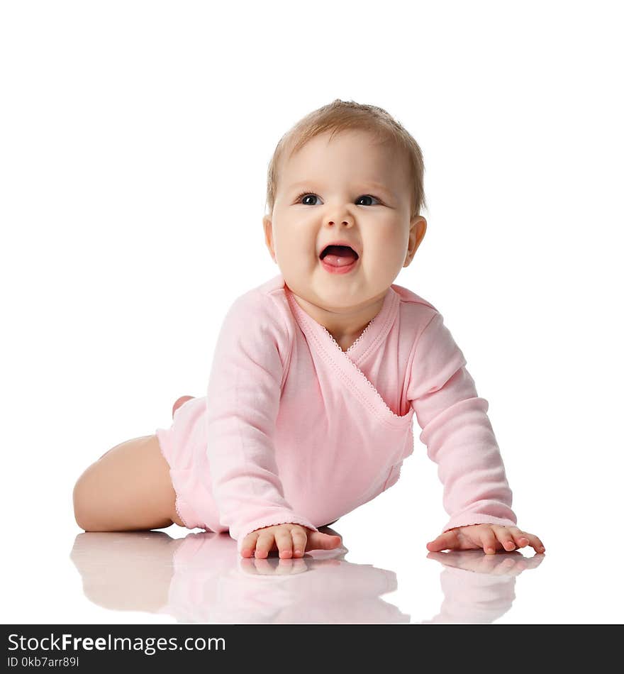 Infant child baby girl toddler lying in pink shirt learning to crawl happy screaming on a white