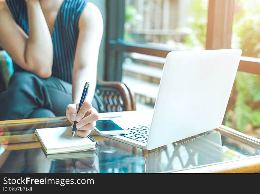 Business Woman Hand Is Writing On A Notepad With A Pen And Using