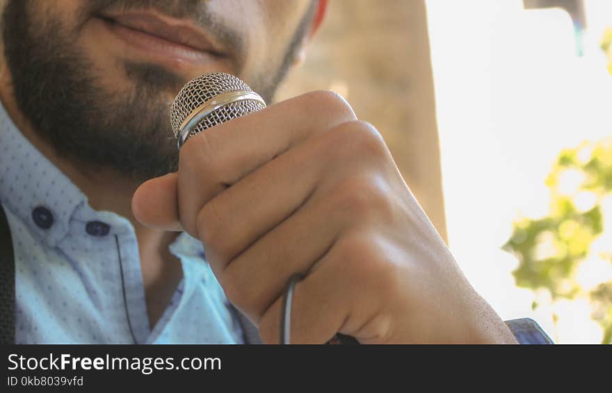 Close-up Photo of Man Holding Microphone