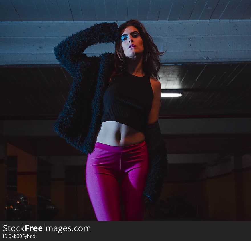 Woman in Black Tank Top and Black Jacket Standing While Right Hand Near Head