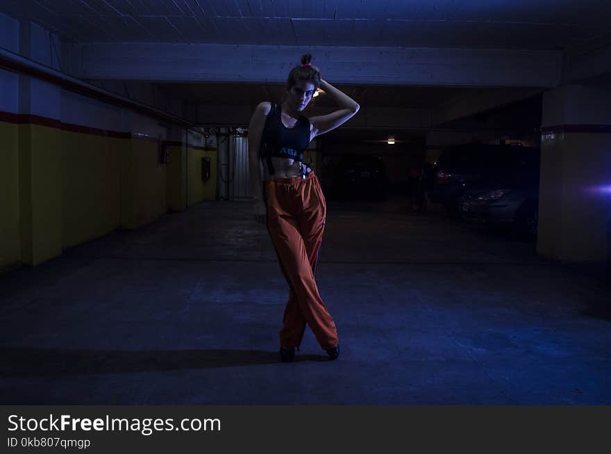 Woman Wearing Black Crop-top and Orange Pants Inside Parking Lot