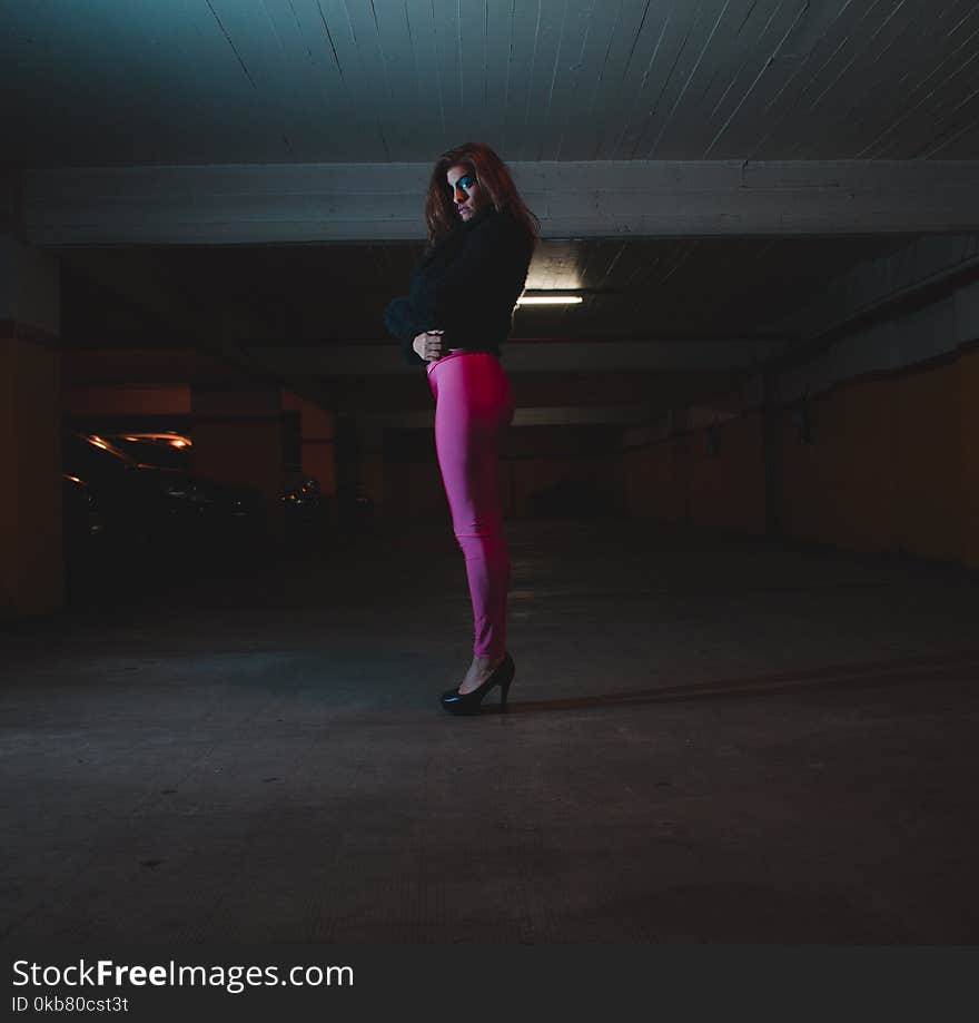 Photo of Woman Wearing Black Shirt and Pink Leggings in Parking Area