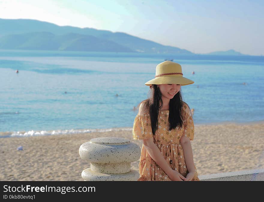 Woman Wearing Brown Off-shoulder Dress Near Ocean Water