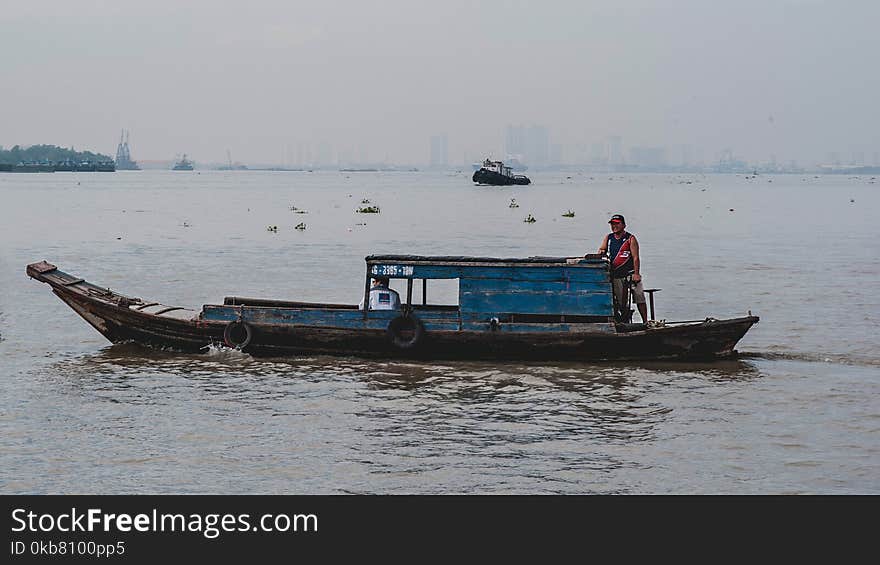 Photo of Man on Wooden Boat