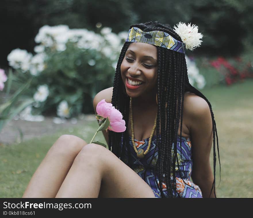 Photography of a Woman Looking at Flower