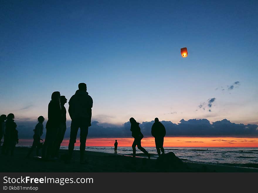 Silhouette of people by the sea.