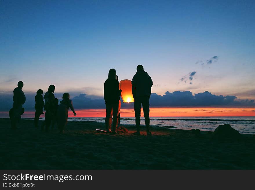 Silhouette of People by the Sea