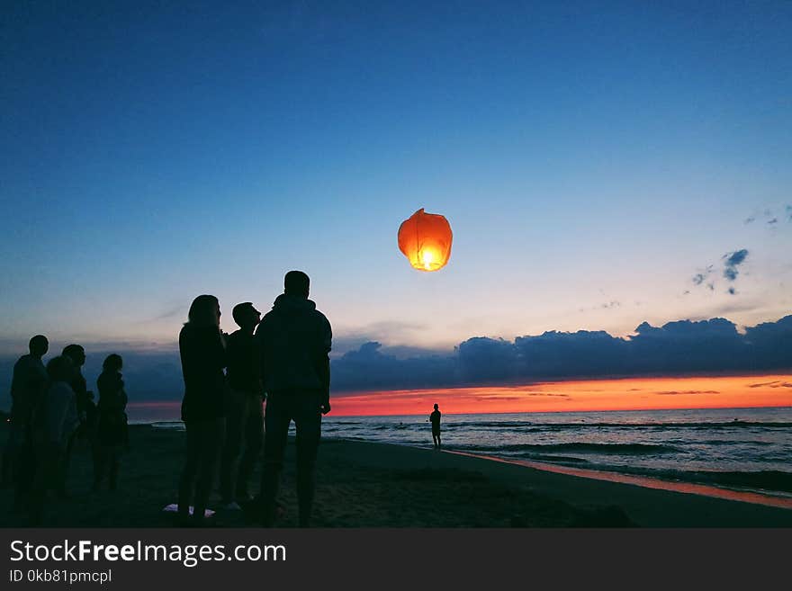 Silhouette of people by the sea.