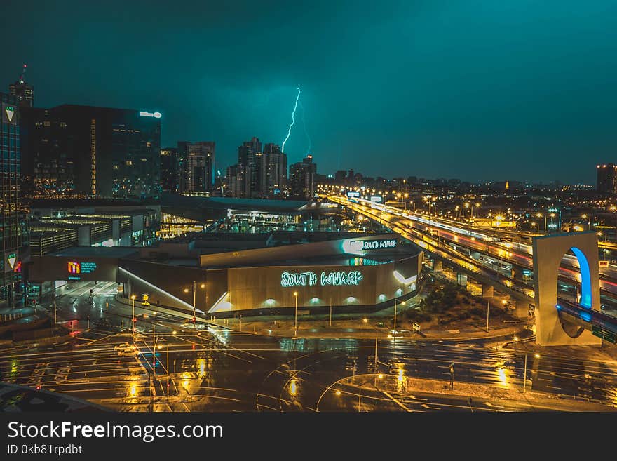 Bird&#x27;s Eye View of Grey Building Near Road and Thunder Lighting Strike in Background