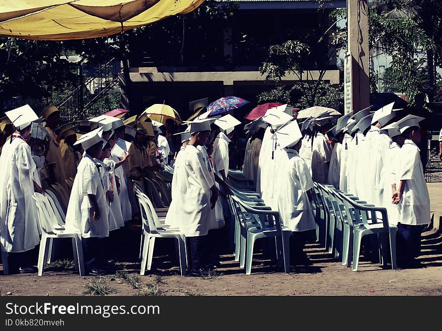 Children Wearing White Academic Gown during Graduation Ceremony at Daytime