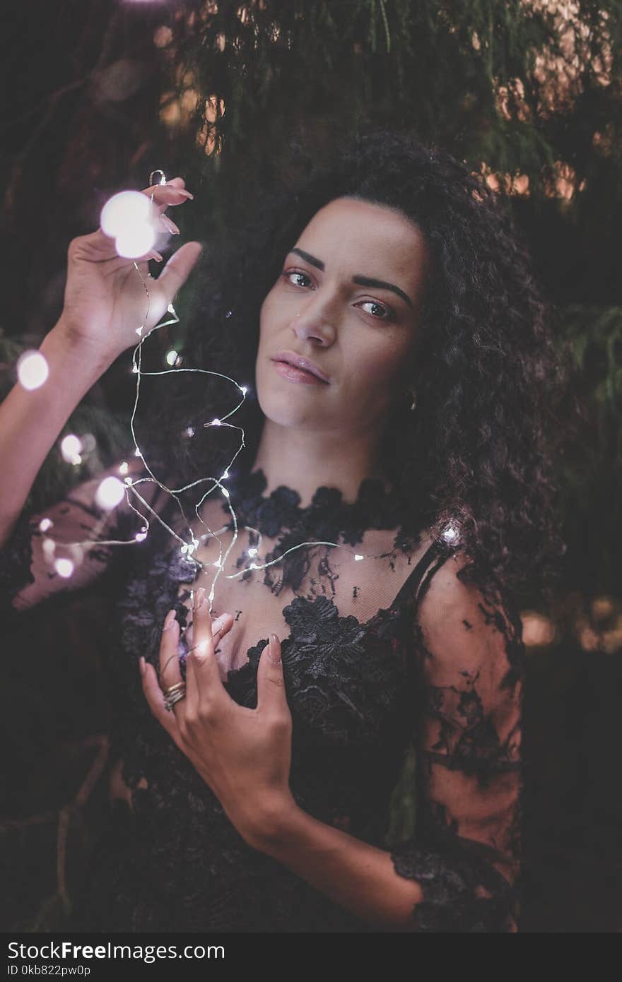 Photography of a Woman Holding String Lights