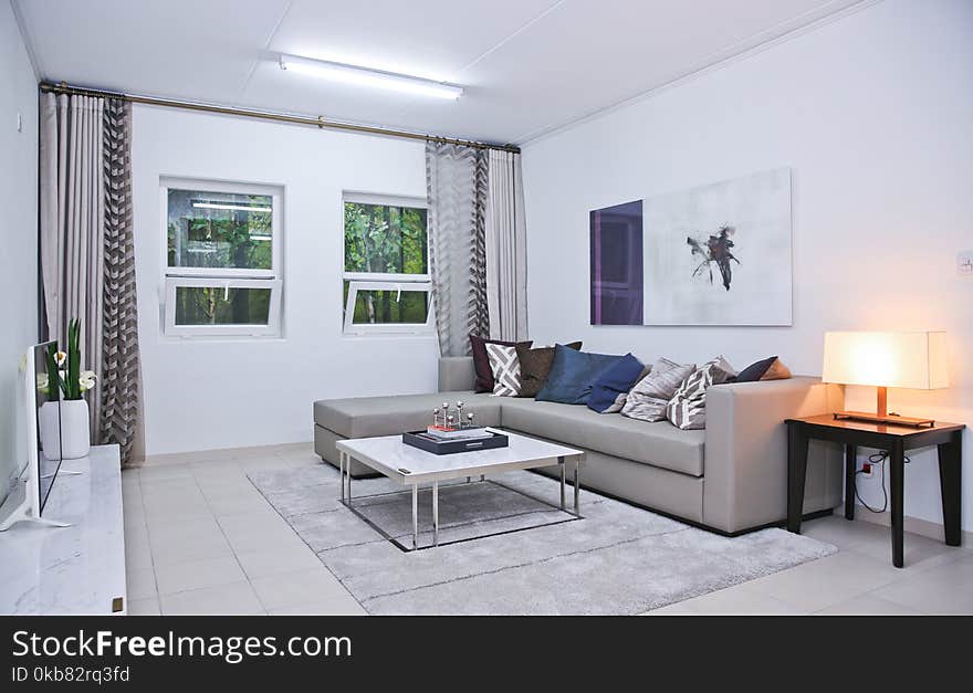 Gray Fabric L-shape Sofa and Assorted-color Throw Pillows in White Living Room