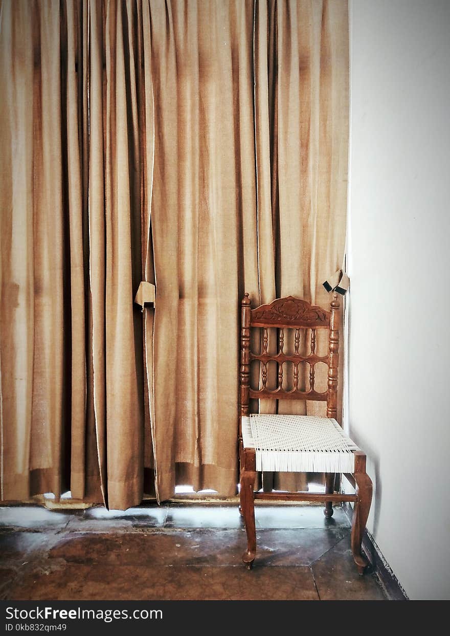 Brown And White Wooden Chair Beside A Brown Window Curtain