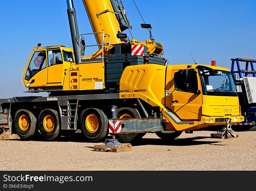 Yellow Crane Truck Parked on Brown Field