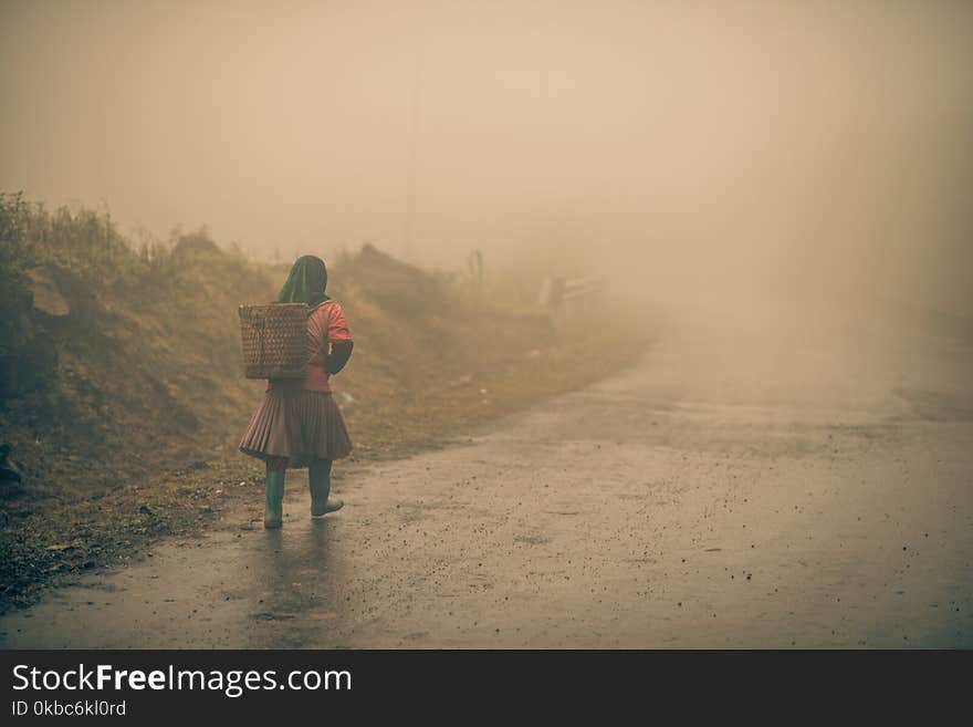 A farmer walks along a foggy road in vietnam